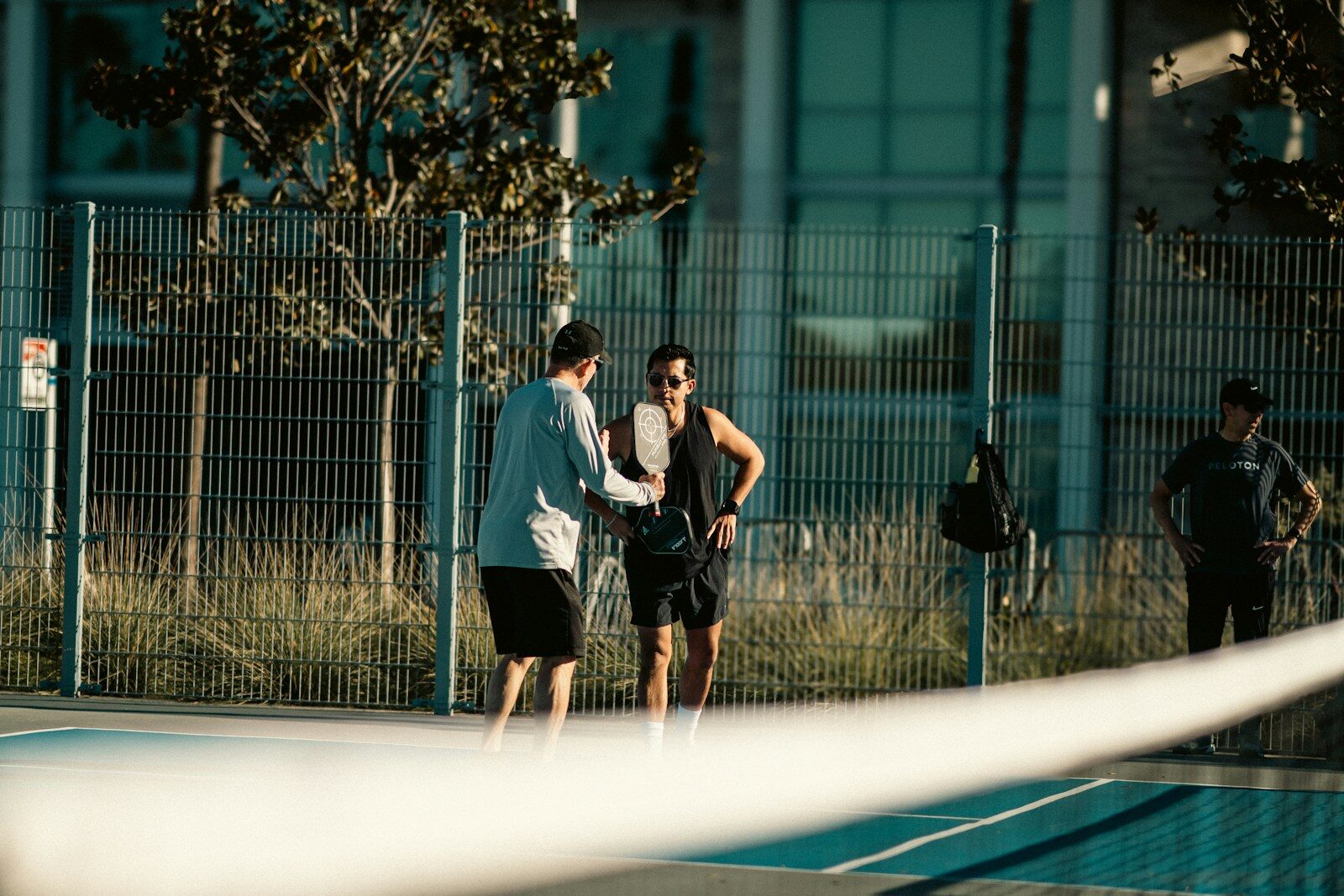 A group of people standing on top of a tennis court